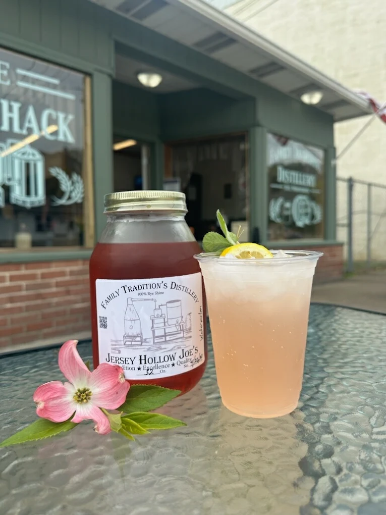 Jersey Hollow Joe's Rye Shine quart alongside a fresh watermelon cocktail outside The Shine Shack in Confluence, PA