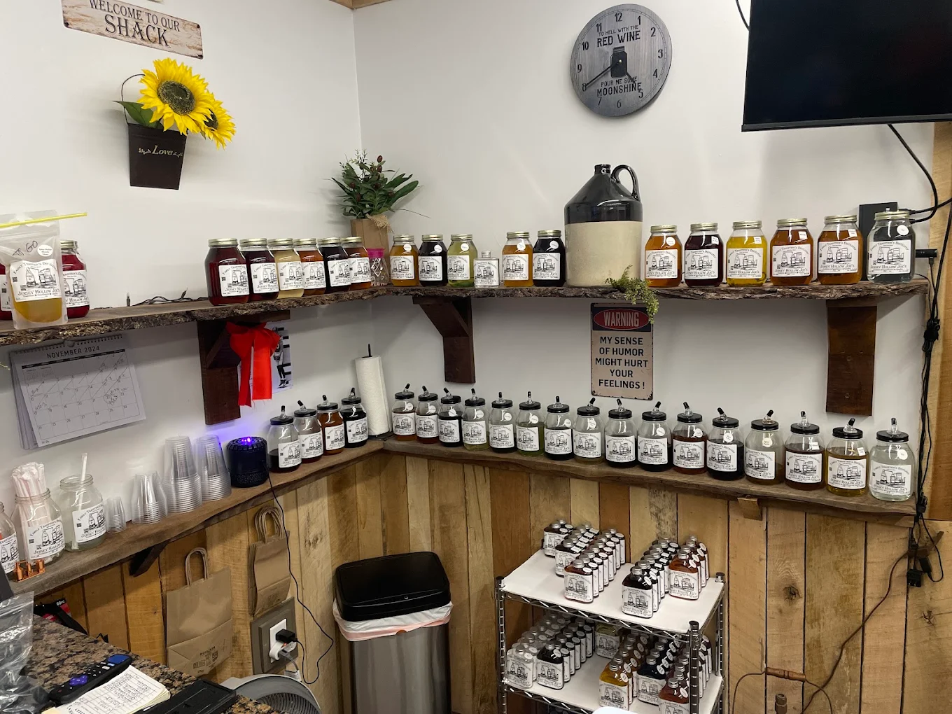 Shelves of Jersey Hollow Joe's moonshine jars and tasting bottles inside The Shine Shack